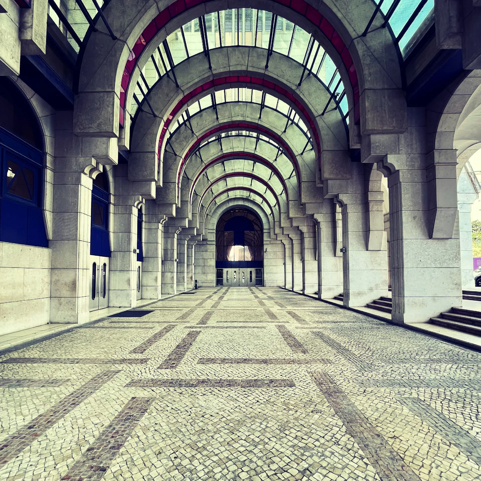 Kamienna arkada z powtarzającymi się łukami i portugalską kostką brukową