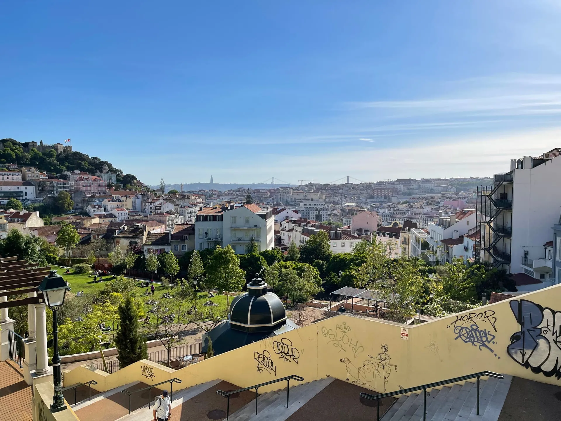 Taras widokowy w Lizbonie z panoramą czerwonych dachów i błękitnym niebem